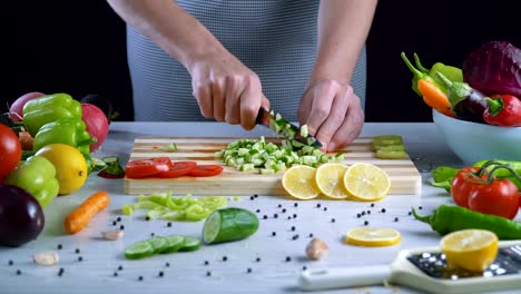 Man-is-cutting-vegetables-in-the-kitchen,-slicing-cucumber