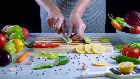 Man-is-cutting-vegetables-in-the-kitchen,-slicing-cucumber