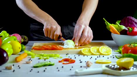 Man-is-cutting-vegetables-in-the-kitchen,-slicing-onion