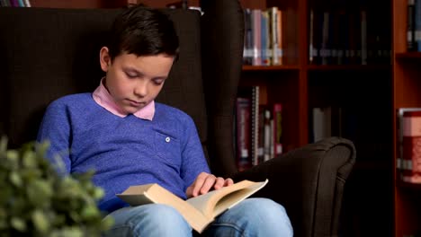 cute-schoolboy-uses-the-app-on-his-smartphone-while-sitting-in-a-chair