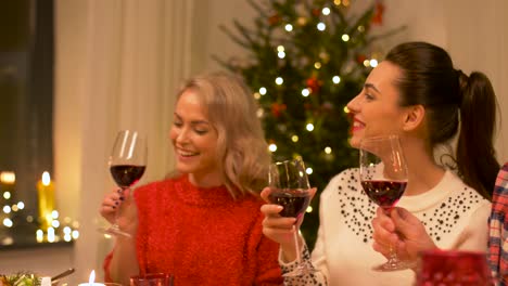 amigos-felices-bebiendo-vino-tinto-en-Navidad
