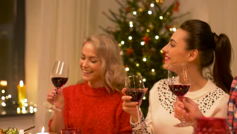 Glückliche-Freunde-trinken-Rotwein-zu-Weihnachten