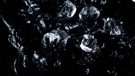 Falling-of-cubes-of-ice-on-a-black-background.-Slow-motion.