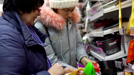 Two-female-customers-choose-kitchen-accessories-in-the-hardware-store.