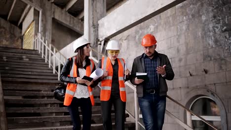 Die-Vorarbeiter-und-zwei-Frauen-Inspektoren,-die-Besichtigung-der-Baustelle.