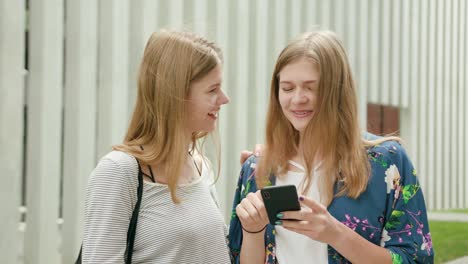 Young-Ladies-Using-a-Phone-in-Town