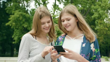 Señoritas,-utilizando-un-teléfono-en-la-ciudad