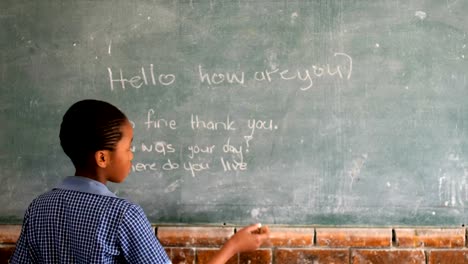 Schoolgirl-writing-on-chalkboard-in-classroom-4k