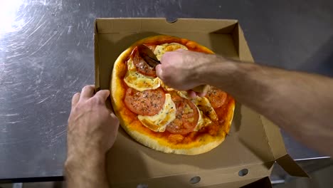 Mann-Chef-schneidet-die-köstliche-heiße-und-leckere-Pizza-hautnah