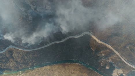 Imágenes-aéreas-de-un-bosque-quemado-para-arriba-con-un-camino-y-un-río-cerca-de