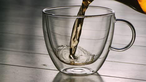 Hot-tea-being-poured-into-glass-in-slowmotion