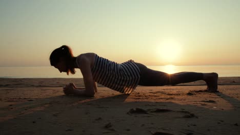 Streching-activo-joven-y-practicar-yoga-en-la-playa-al-atardecer.