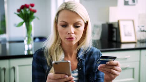 Hermosa-mujer-rubia,-escribir-los-datos-de-tarjeta-de-crédito-en-teléfonos-inteligentes