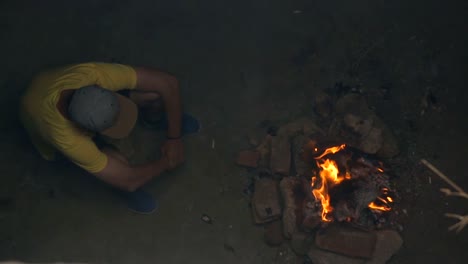 Young-man-sitting-by-campfire