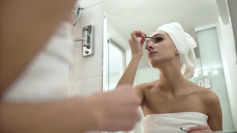 Maquillaje-en-el-baño.-Mujer-aplicar-rimel-en-las-pestañas