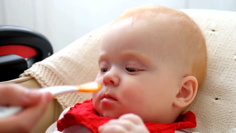 Mother-gives-baby-food-from-a-spoon