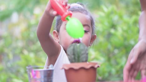 Madre-e-hijo-están-regando-plantas-juntas.