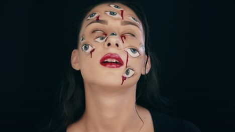 Kunst-Halloween-Make-up,-Frau-hat-viele-Augen-auf-ein-Gesicht