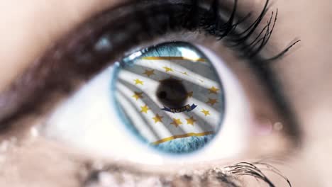 Woman-blue-eye-in-close-up-with-the-flag-of-Rhode-Island-state-in-iris,-united-states-of-america-with-wind-motion.-video-concept