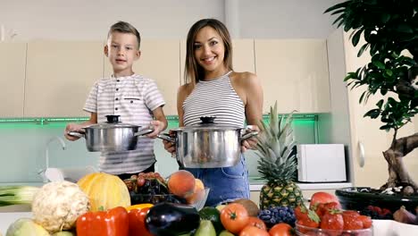 Küche-und-Essen.-Mutter-und-Sohn-halten-einen-Topf-zum-Kochen.