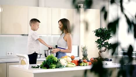 Küche-und-Essen.-Mutter-und-Sohn-halten-einen-Topf-zum-Kochen.