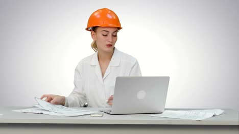 Young-engineer-woman-reading-technical-drawings-on-white-background
