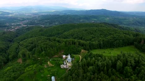 Christian-church-on-top-of-green-hill,-aerial-view