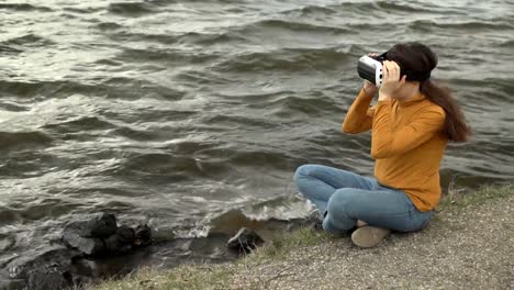 Eine-junge-Frau-nutzt-virtual-Reality-Brille-neben-starken-Wellen.