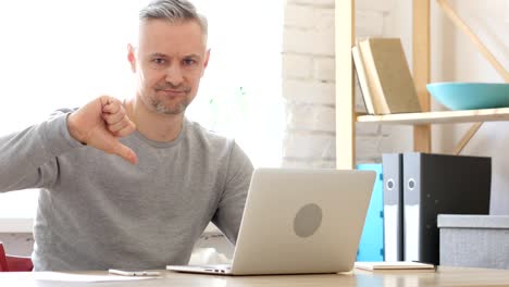 Thumbs-Down-by-Middle-Aged-Man-Working-on-Laptop