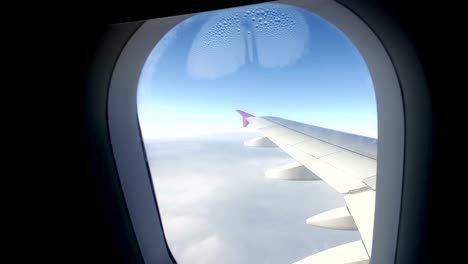 Passagier-POV-Blick-durch-das-Fenster-vom-Flugzeug-fliegen-über-den-Wolken