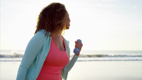 African-American-female-exercising-with-weights-at-sunset