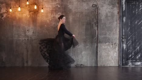 Schöne-weibliche-Tänzerin-in-einem-langen-schwarzen-Kleid