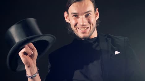 Magician-portrait.-Illusionist-is-twisting-hat-on-his-finger-and-making-faces.