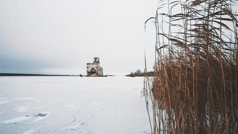 Zerstörte-Kirche-Gebäude-in-der-Mitte-des-zugefrorenen-See-mit-Schnee-bedeckt