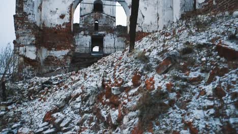 Ruins-of-old-orthodoxal-cathedral-building,-piles-of-bricks-covered-in-snow