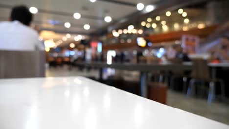 Blurred-unrecognizable-people-walking-in-terminal.-Unrecognizable-passengers-going-in-waiting-hall.-Defocus-background-from-busy-big-airport-with-people-stepping-for-the-flight.-Low-angle-view