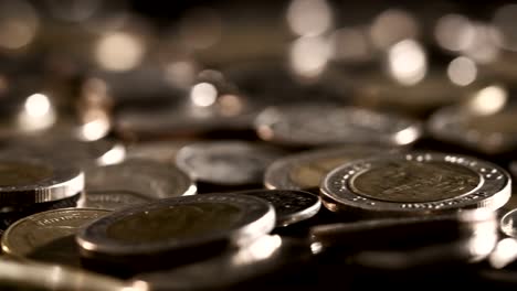 Close-up-money-coin-stacking-on--the-floor-in-dark-light-,-business-and-financial-for-money-saving-or-investment-background-concept--,-extremely-close-up-and-shallow-DOF