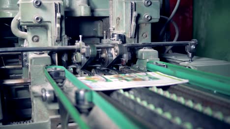 An-industrial-machine-is-cutting-off-edges-of-printed-magazines