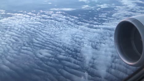 Airplane-view-window-concept.-View-on-window-airplane-see-engine-and-wing-on-cloud-and-sky-blue-or-azure-sky-on-land-beautiful.