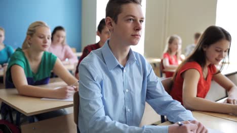 Gruppe-von-Studenten-mit-Notebooks-Test-in-der-Schule-schreiben