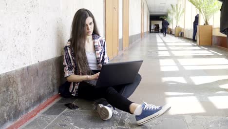 Mädchen-mit-Laptop-in-einem-College-Korridor