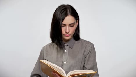 Mujer-hermosa-joven-con-el-pelo-marrón-corto-manteniendo-y-lectura,-concentrado,-fondo-blanco