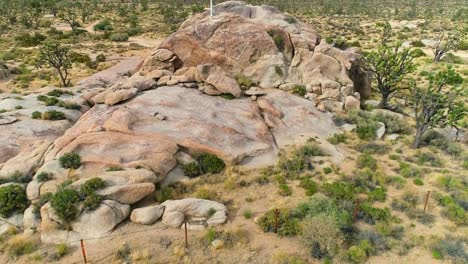 Luftaufnahme-über-ein-weißes-Kreuz-auf-einem-Berg-mitten-in-der-Wüste