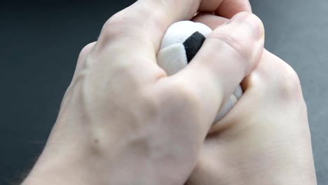 Hand-squeezes-a-small-soccer-ball.