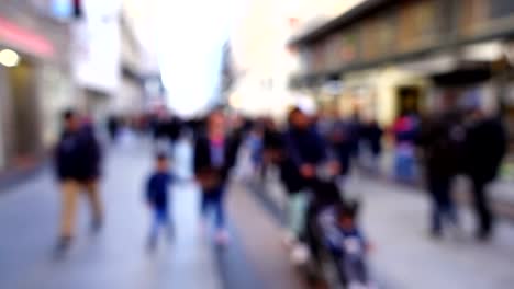 Movimiento-de-personas-a-lo-largo-de-la-calle-Fuencarral.-Fuera-de-foco.-Cámara-lenta.	Madrid,-España.