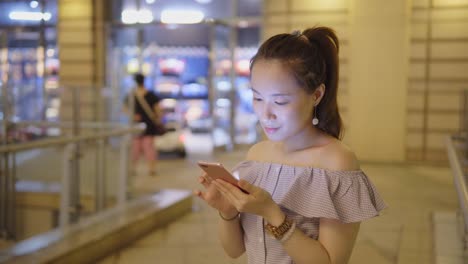 Joven-mujer-de-uso-del-teléfono-móvil-en-el-centro-comercial