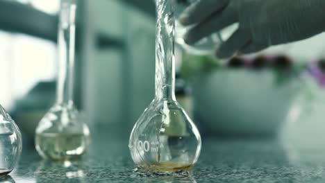 Laboratory-assistant-pours-the-water-into-the-flask