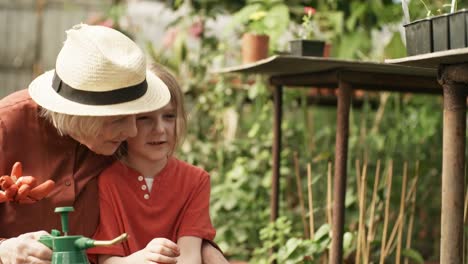 Grandmother-Teaching-Granddaughter-about-Plants-in-Greenhouse