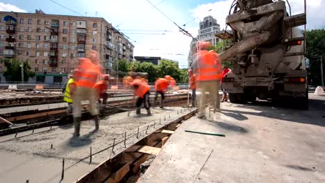 Obras-de-hormigón-para-construcción-de-mantenimiento-de-carreteras-con-muchos-trabajadores-y-mezclador-timelapse-hyperlapse