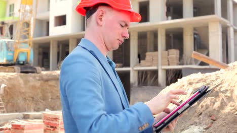 ein-junger-Architekt-arbeitet-auf-einem-Tablet-in-der-Nähe-der-Baustelle